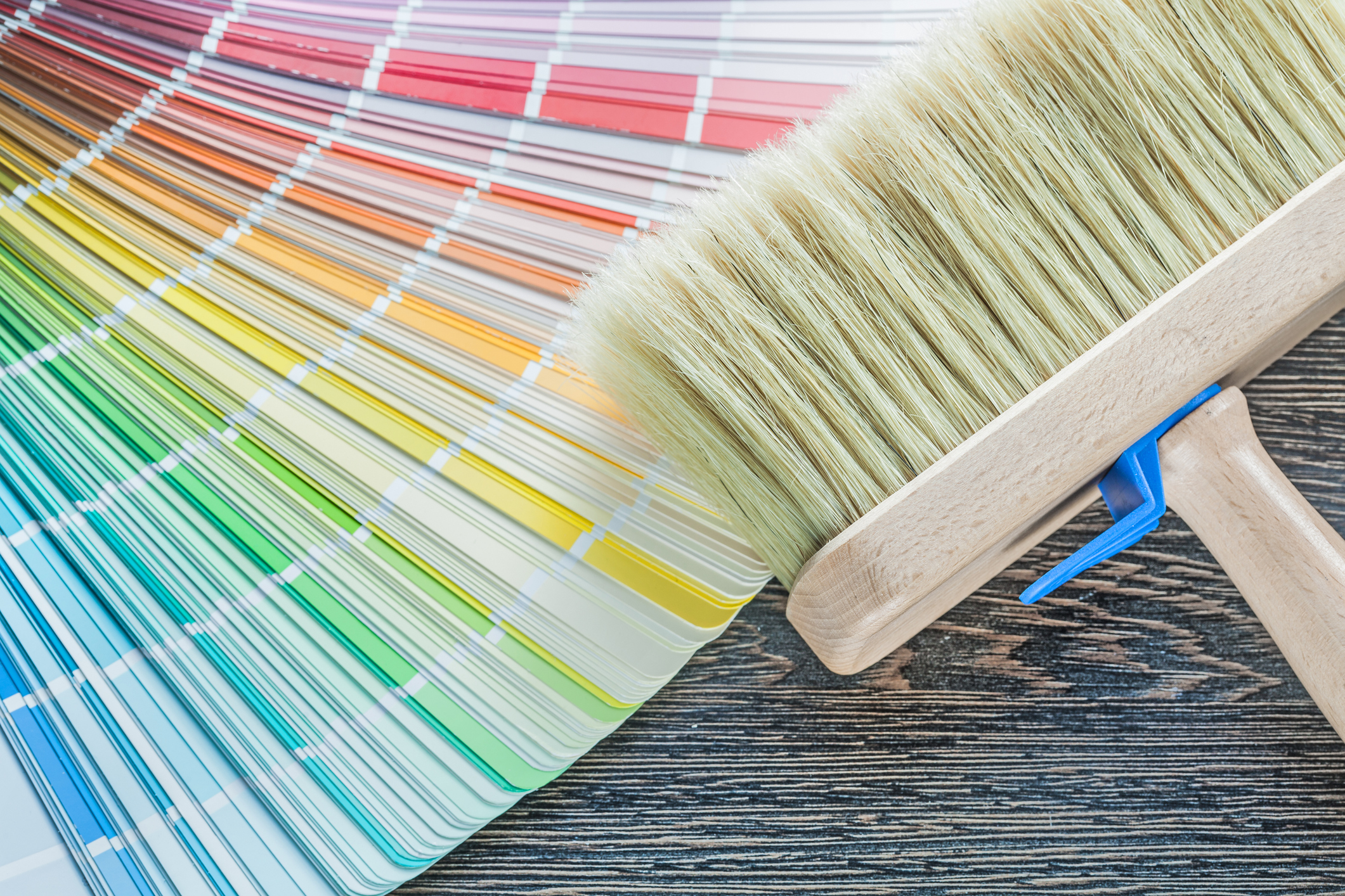 Horizontal image of color palette fan paint brush on wood board